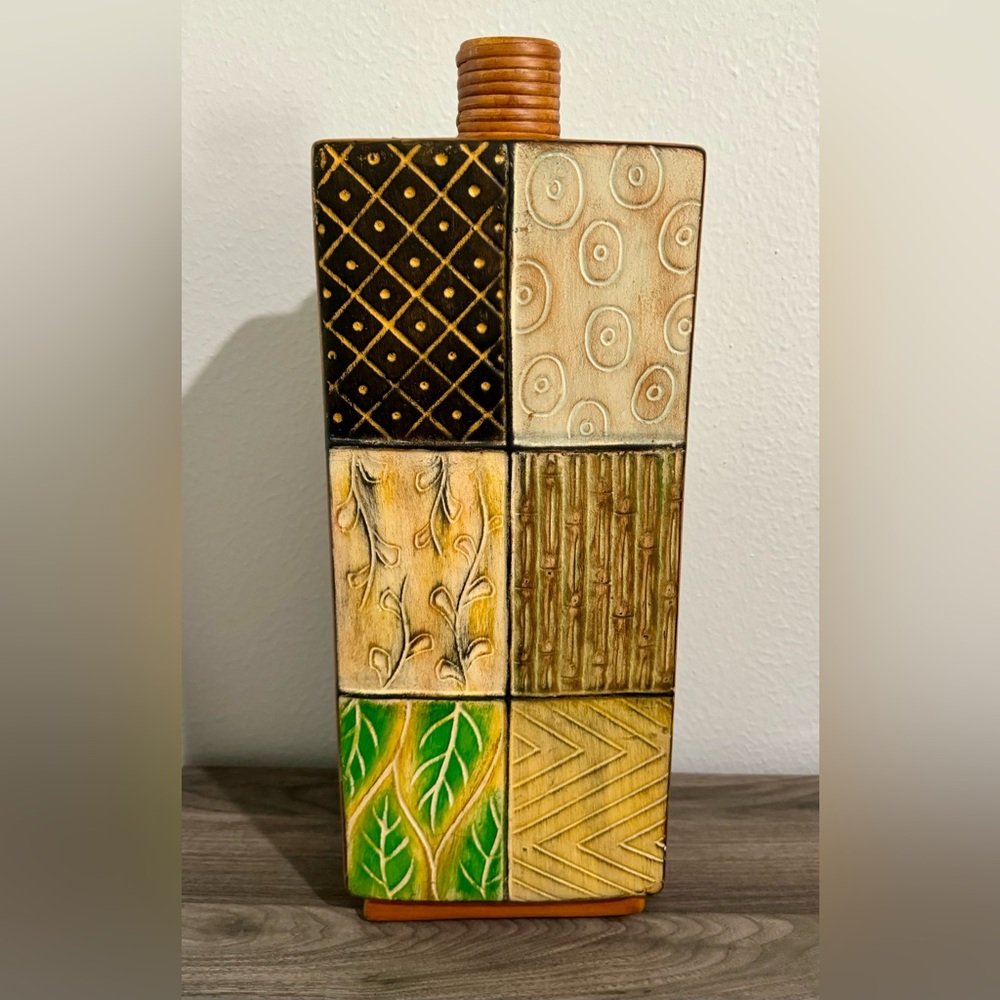 Stylish ceramic vase in the shape of a perfume bottle with a nuanced floral patt